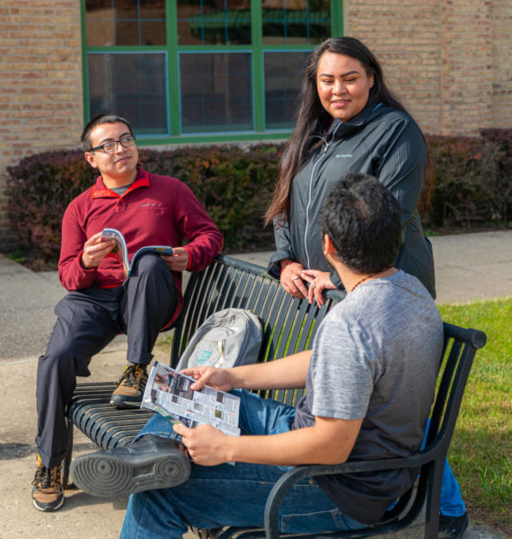 Saint Augustine Students sitting around a bench on the Chicago campus.