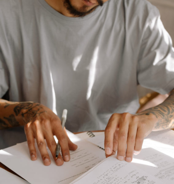 A young man looking over his notes from class.