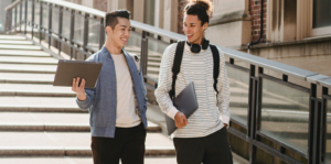 Two students talking while walking down a flight of stairs.