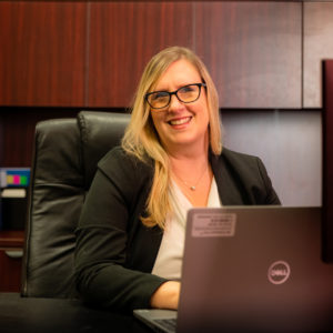 A member of Saint Augustine's faculty sitting behind her computer.