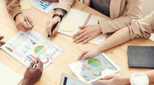 People sitting around a table working on a project together.