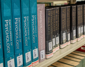 Psychology textbooks on a library shelf.