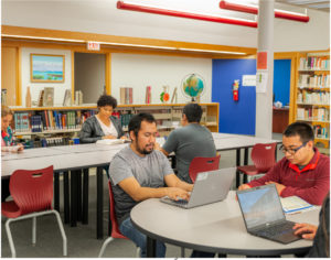 Members of the student body on their computers in Saint Augustine College's library.