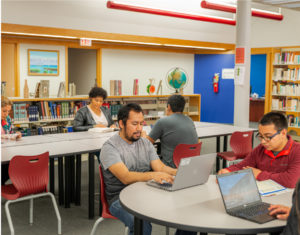 Members of the student body on their computers in Saint Augustine College's library.