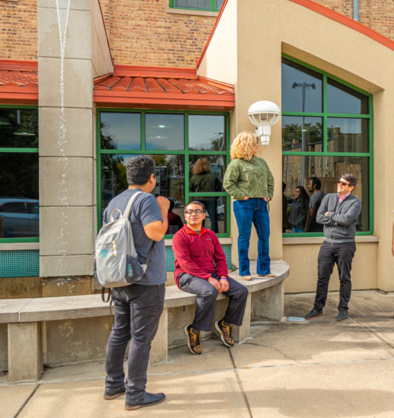 A few students standing in front of Saint Augustine College's front door.