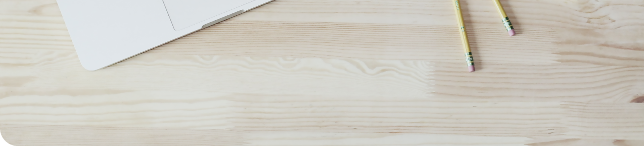 A desk with two pencils and a piece of paper.