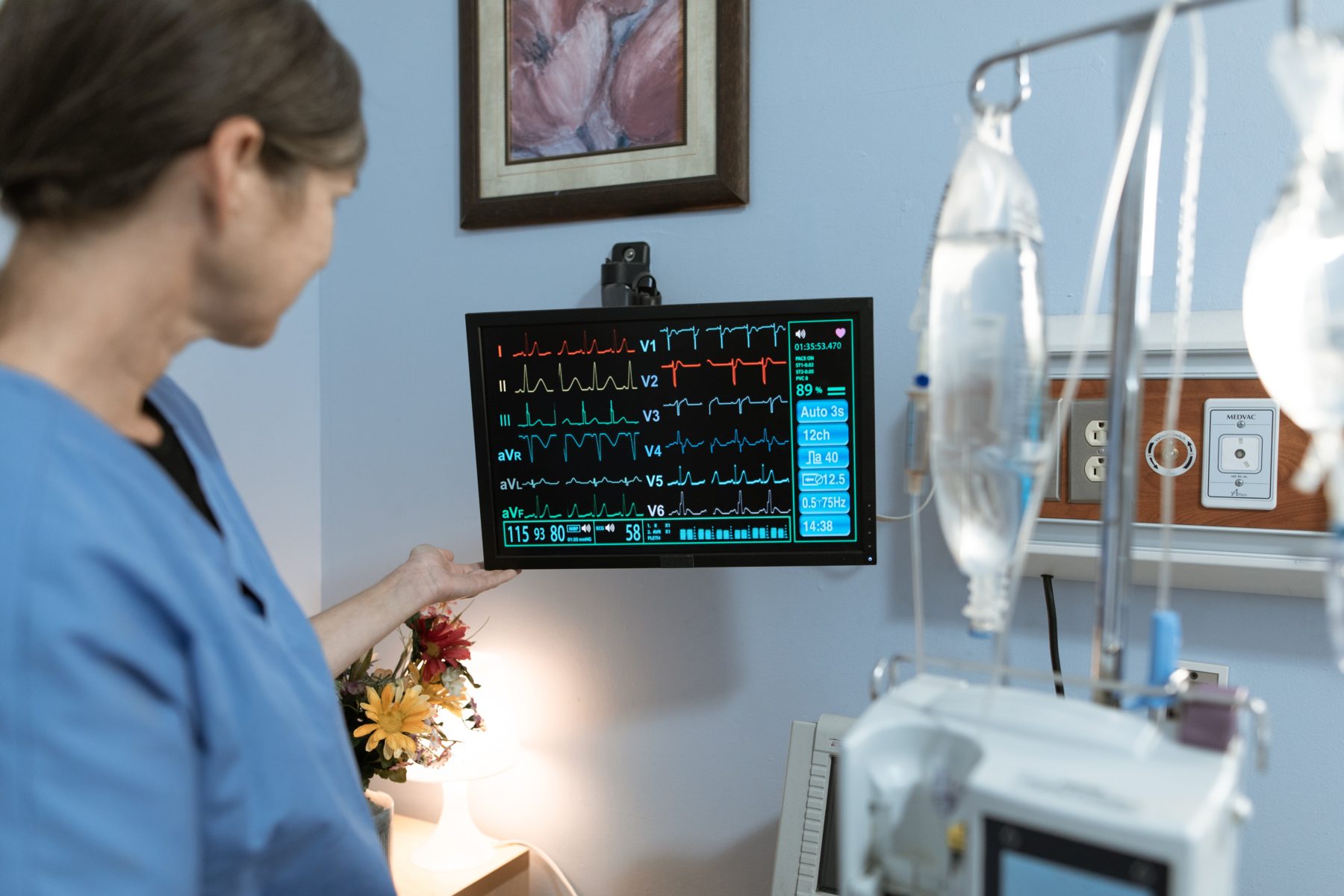 A respiratory therapy technician examines a patient's vitals.
