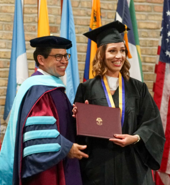 A student graduating from Saint Augustine College, standing alongside the President of SAC.