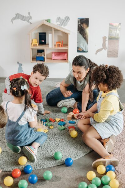 A woman playing with a few children.