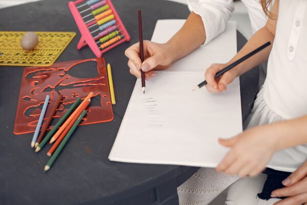 A teacher and child working together to learn how to draw.