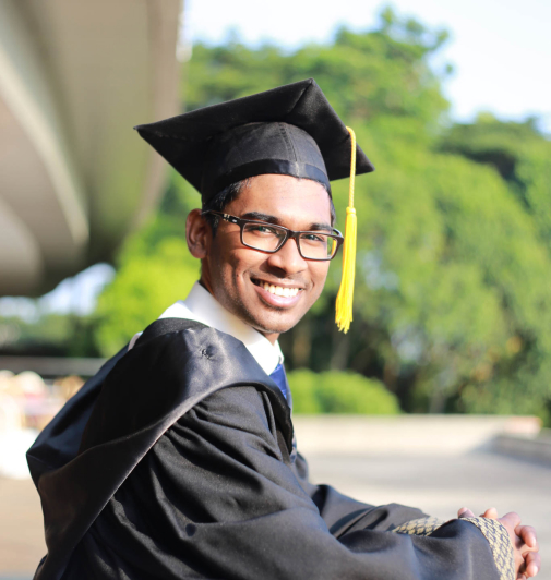 Recent graduate of the BA in Hospitality program at Saint Augustine College wearing his cap and gown.