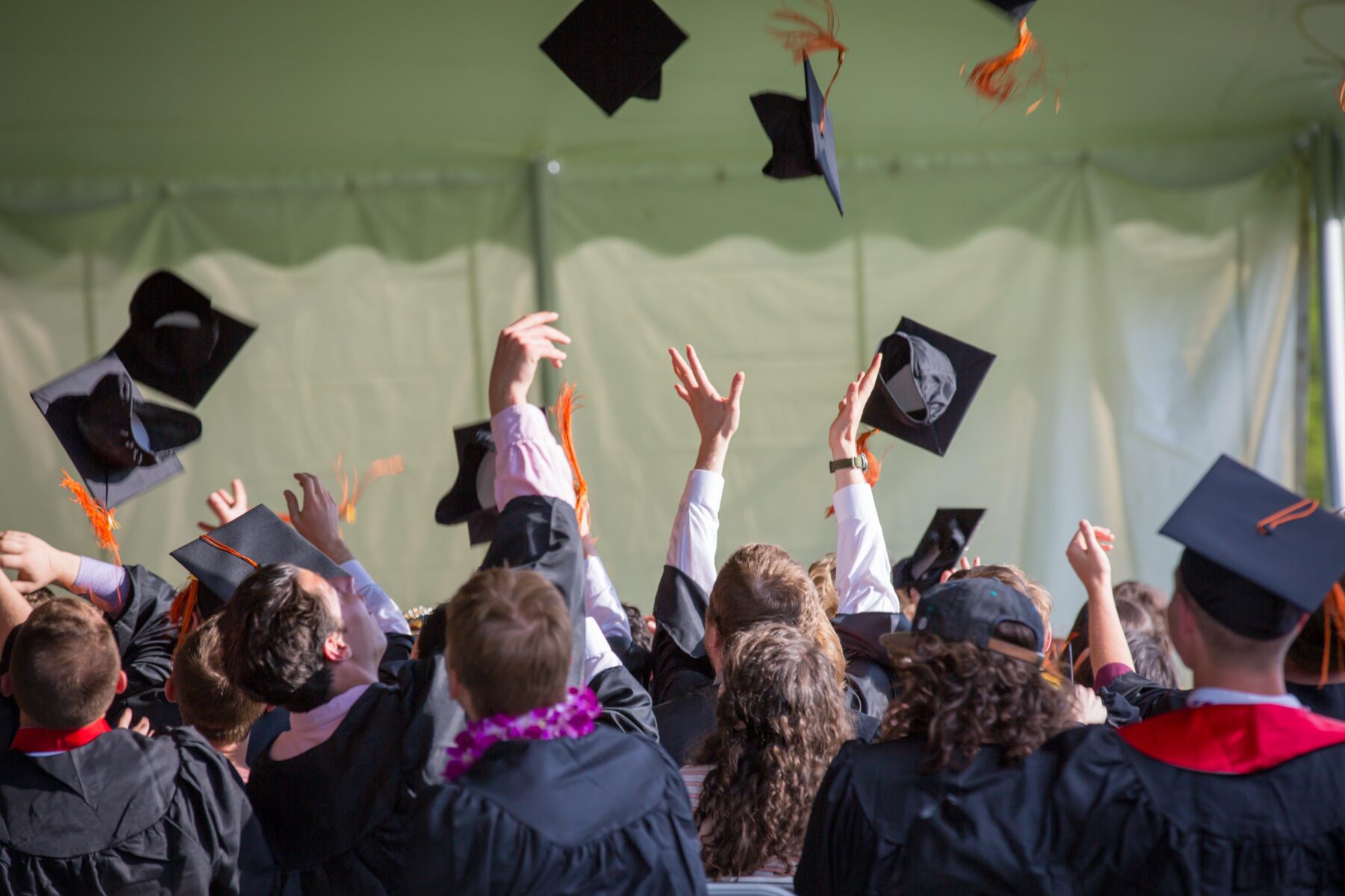 Graduates throwing up their caps in celebration.